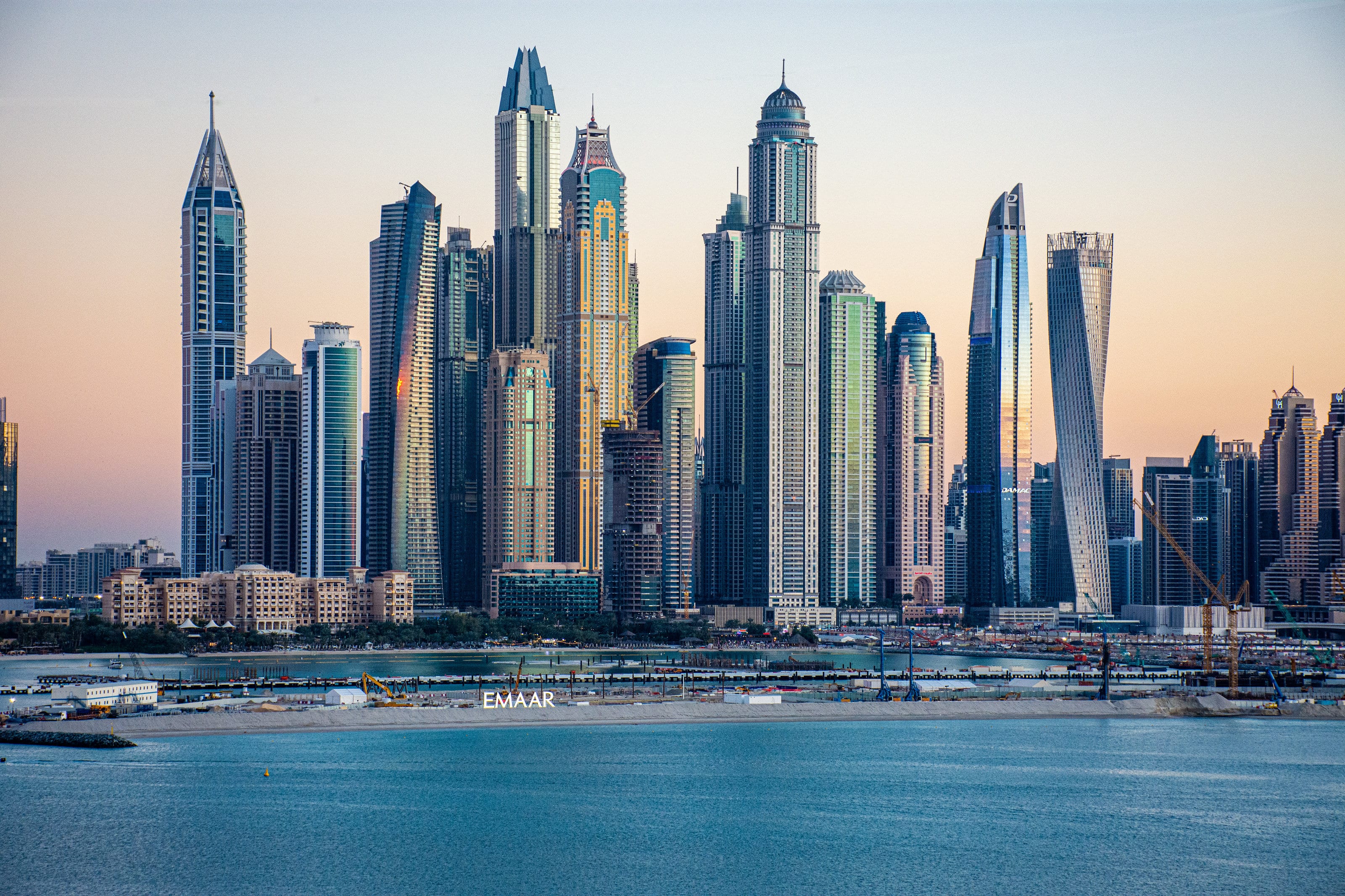 Arranha-céus da Dubai Marina ao entardecer, à beira da água.