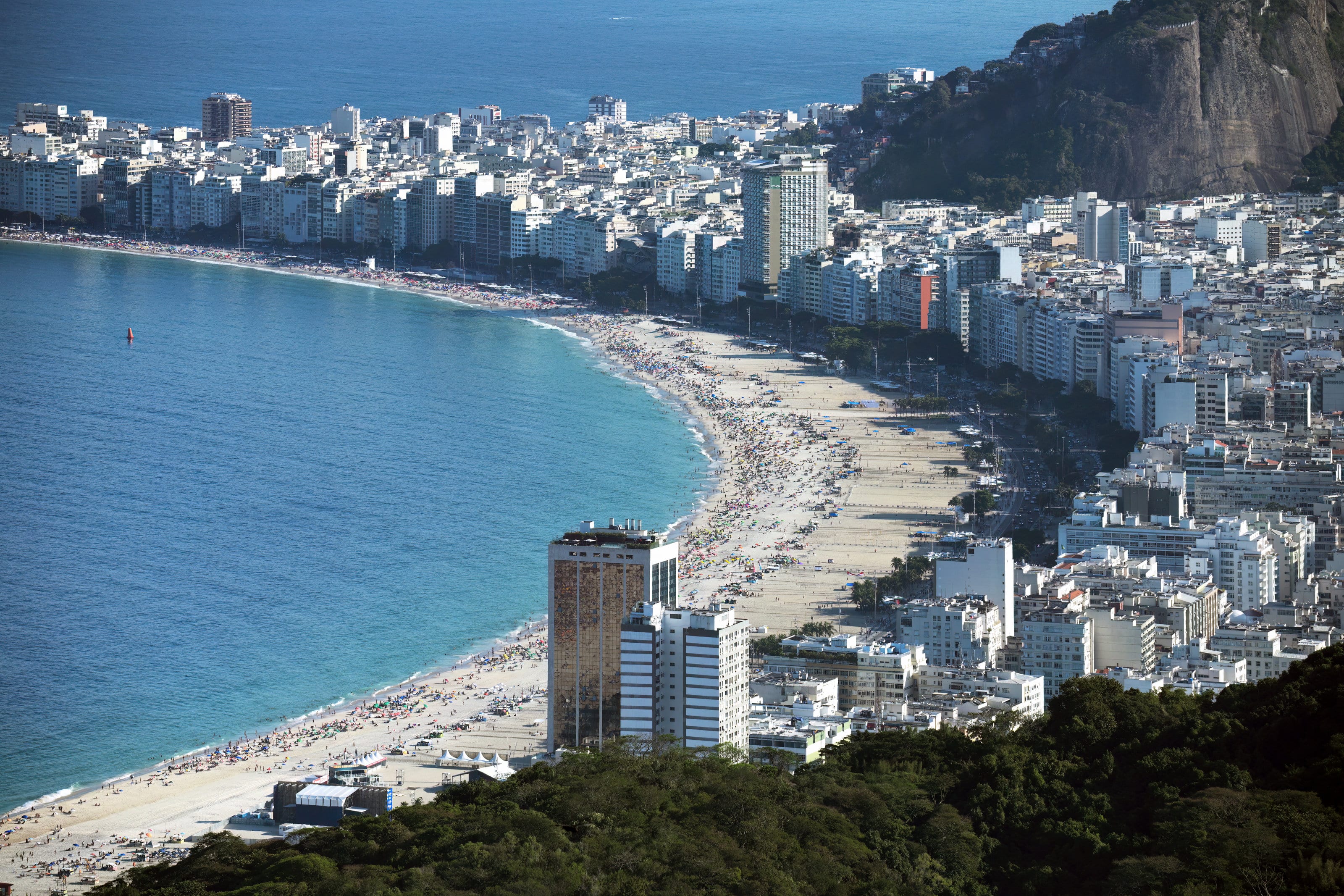 A curva da praia de Copacabana, com o mar azul e os prédios da orla, no Rio de Janeiro.